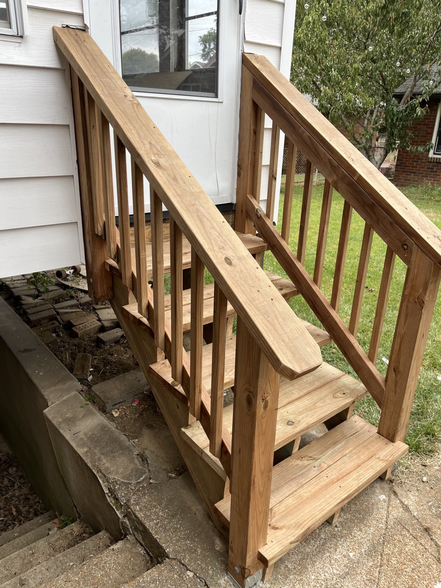 Pressure-treated entry stairs and railing framed at a side door