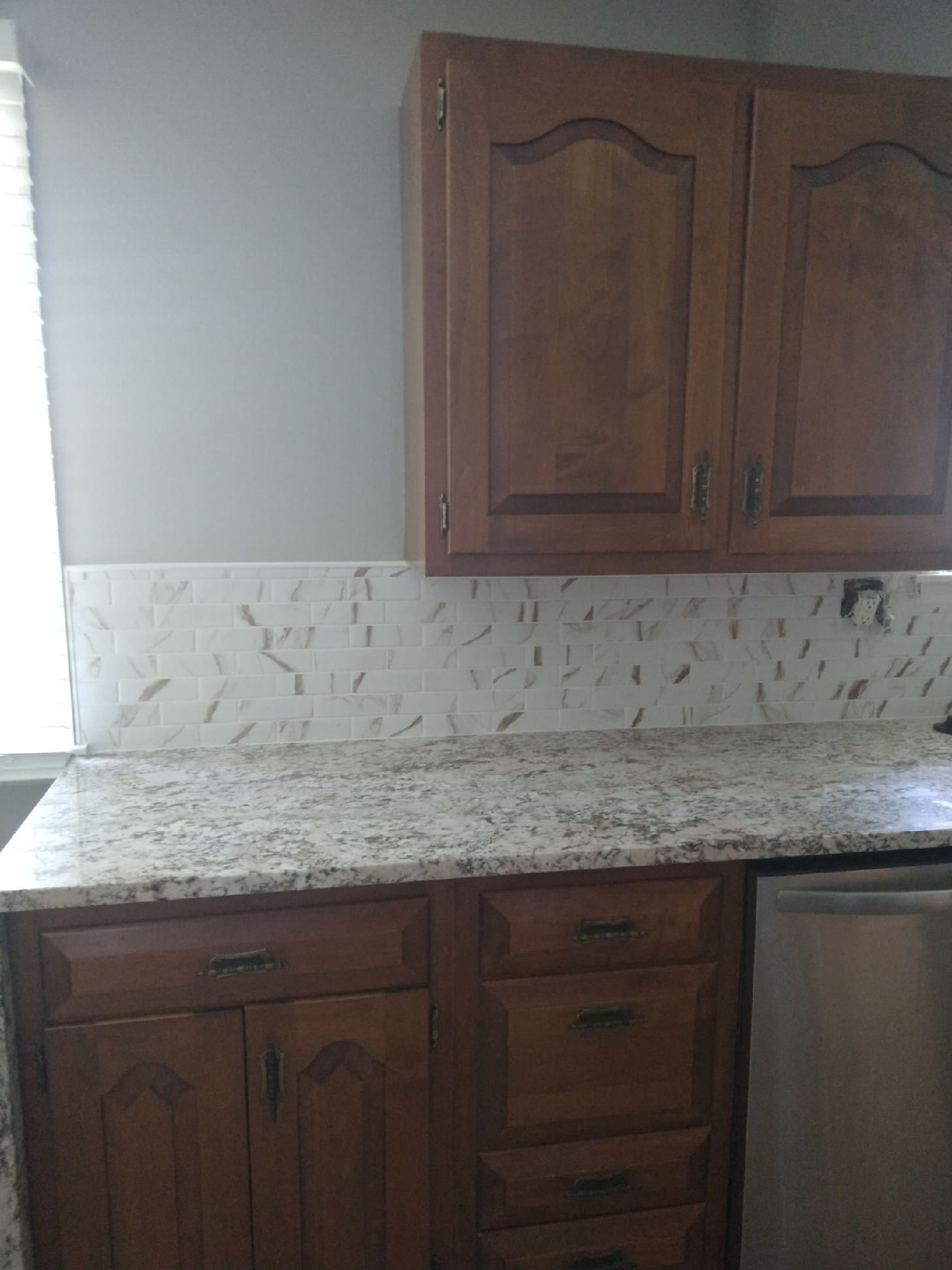 Kitchen remodel with marble-look backsplash and granite countertop