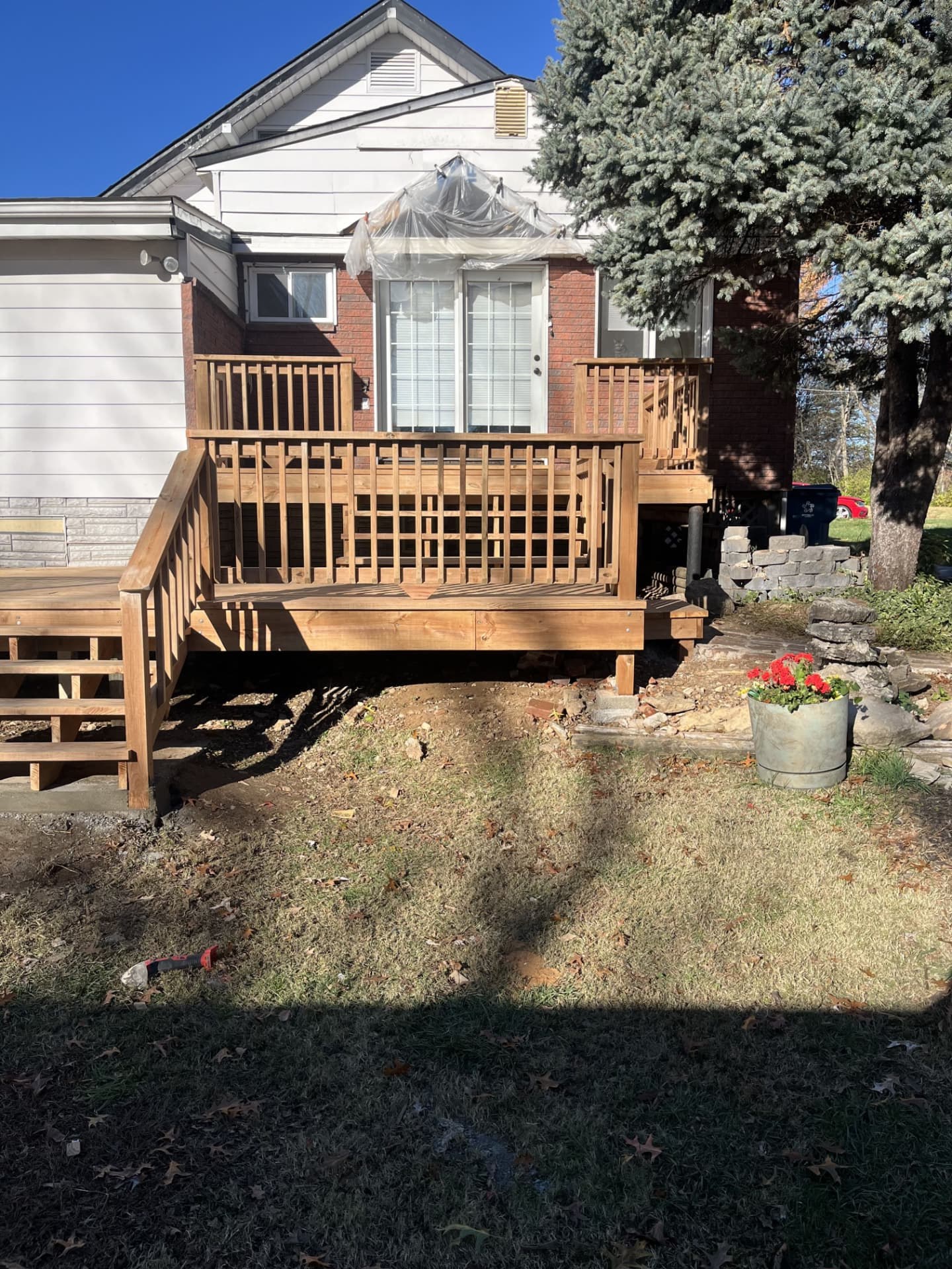 Wraparound deck with stained wood railing and open stair access