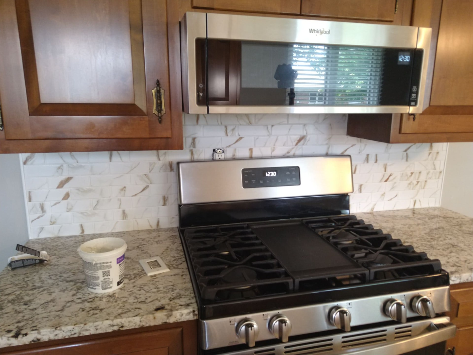 Kitchen remodel with new marble-look backsplash and granite countertops