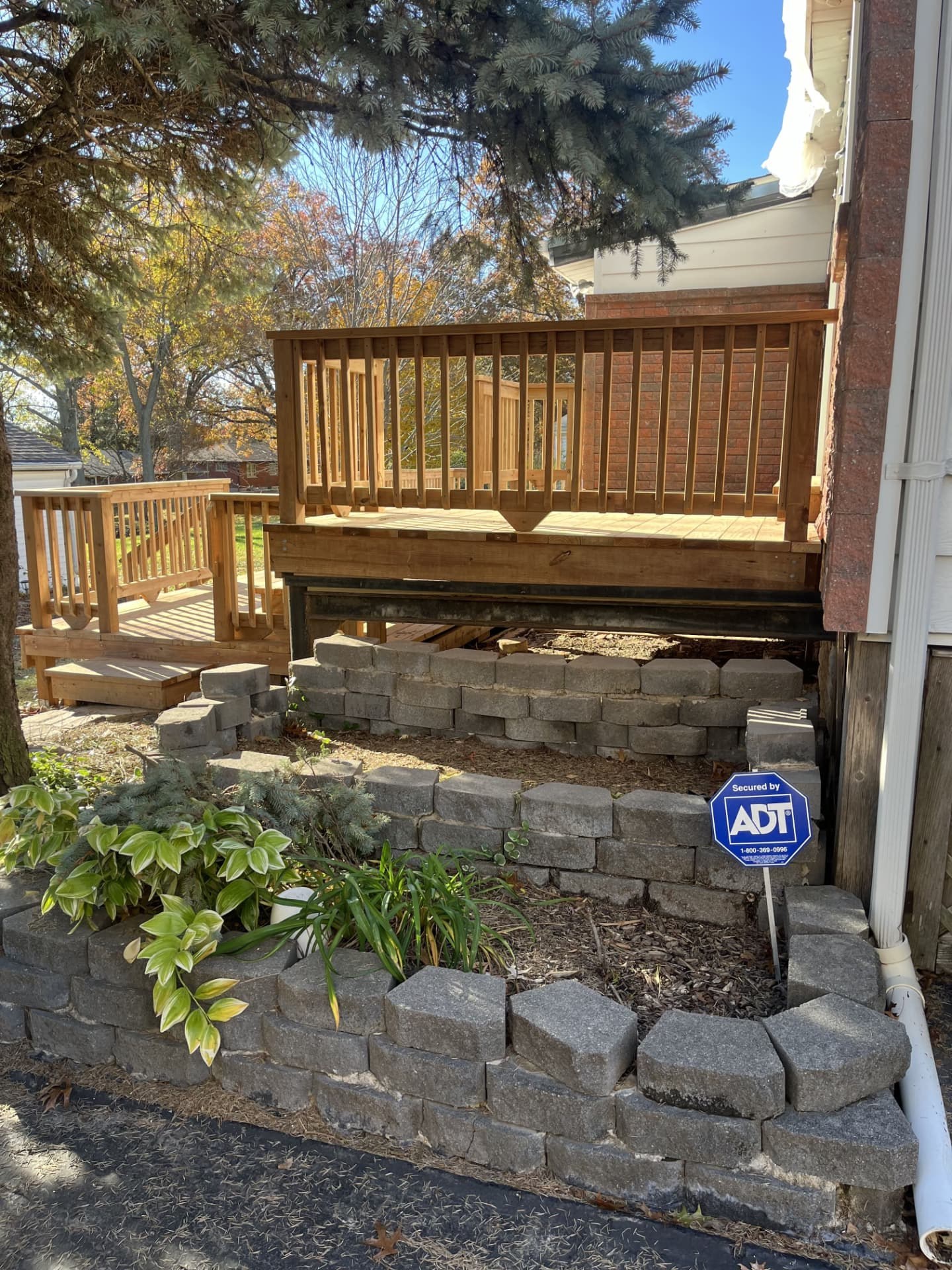 Cedar deck landing and steps built above a stone retaining wall