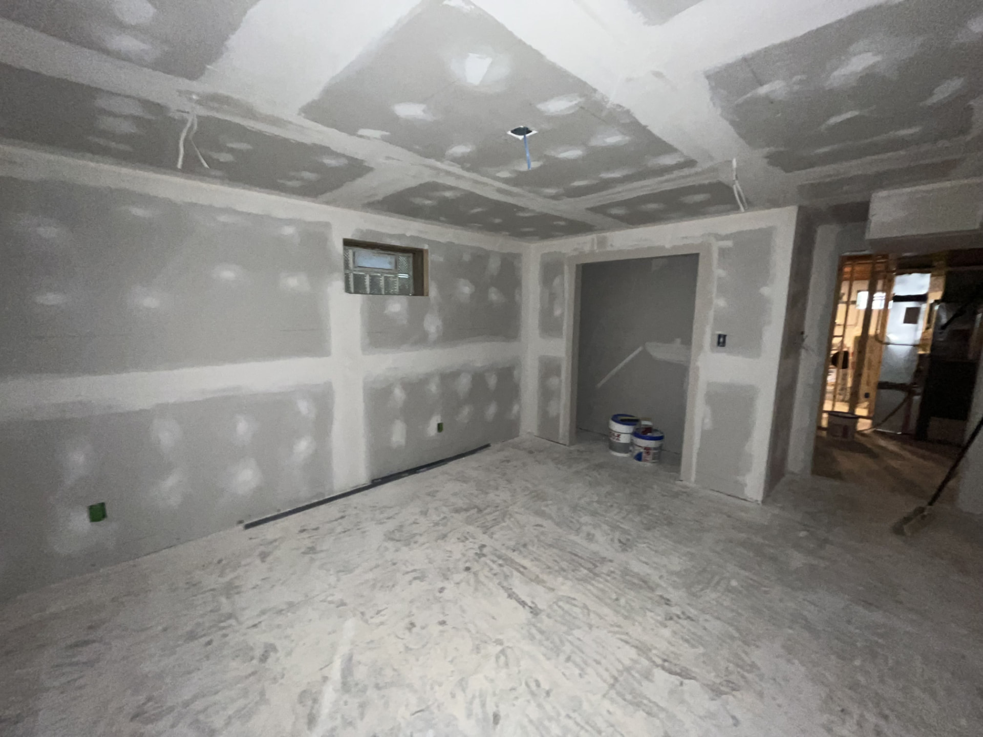 Drywall hung with mud and tape finish work in progress