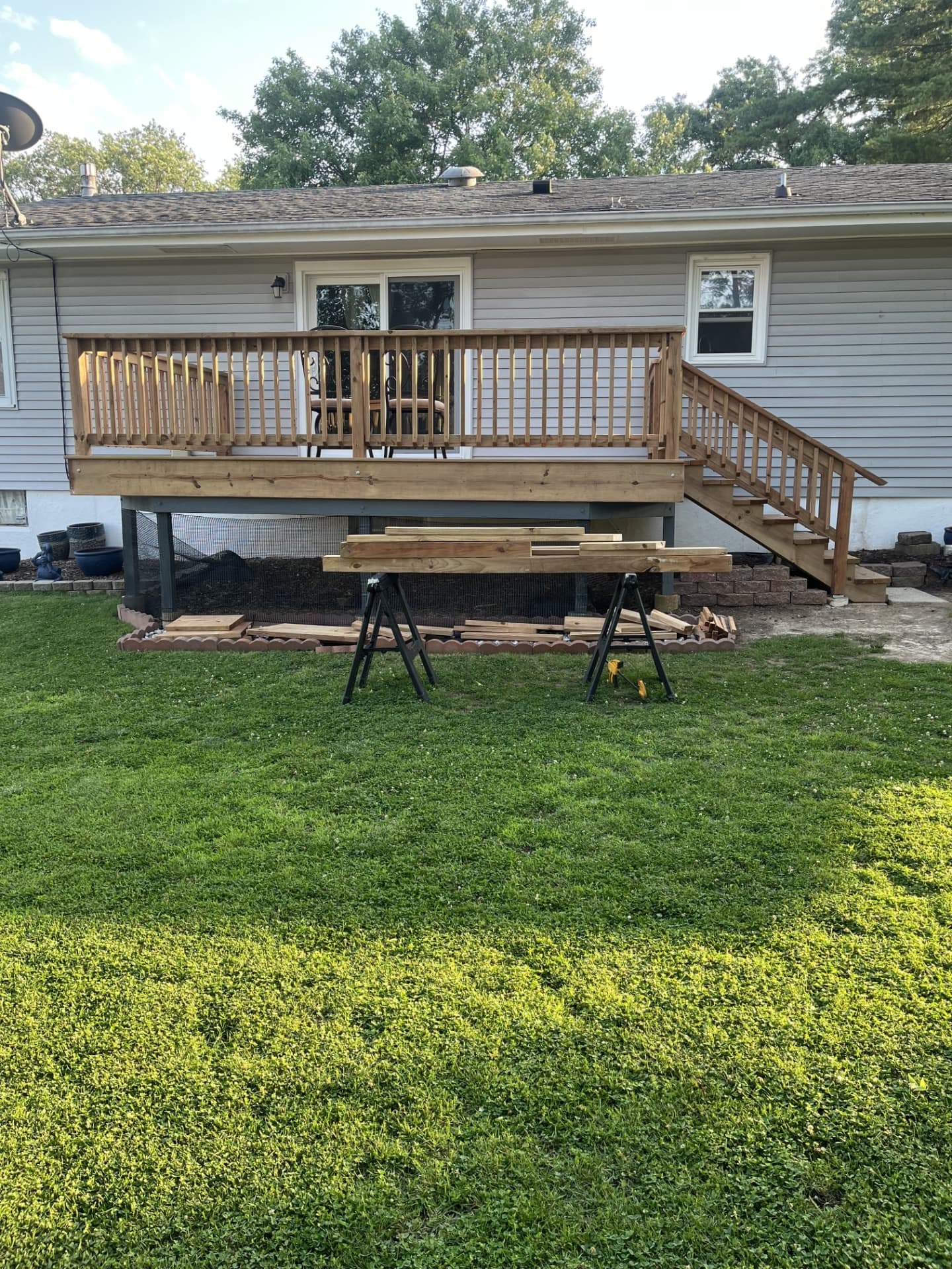 Backyard deck with railing overlooking a green lawn