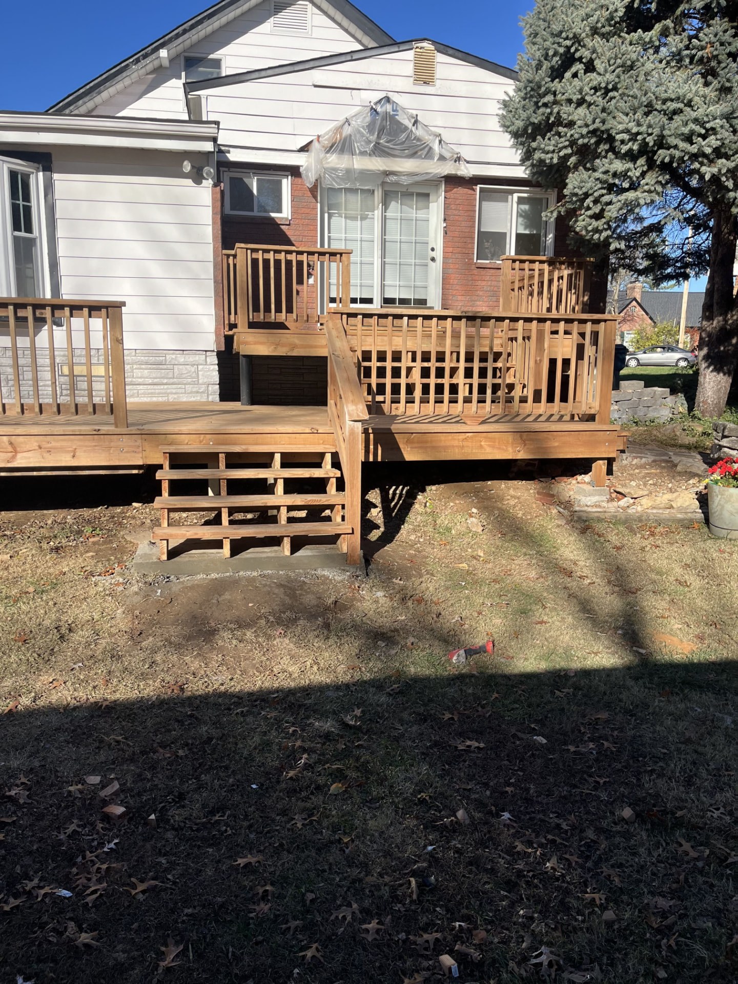 Multi-level wood deck with railings wrapping a brick and siding home