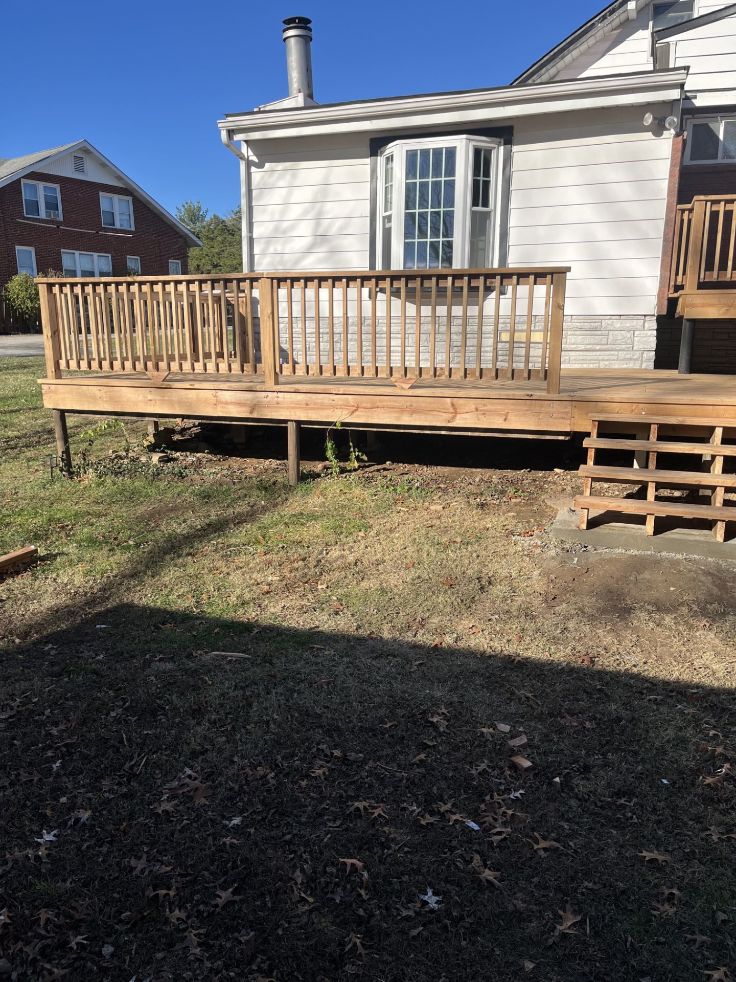 New wood deck and stairs built on the back of a brick home