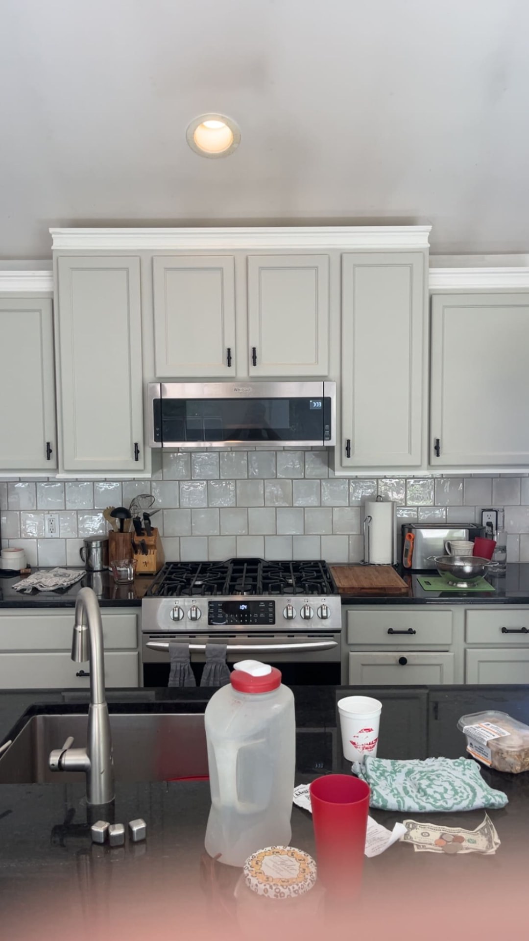 Remodeled kitchen with grey cabinets and white tile backsplash