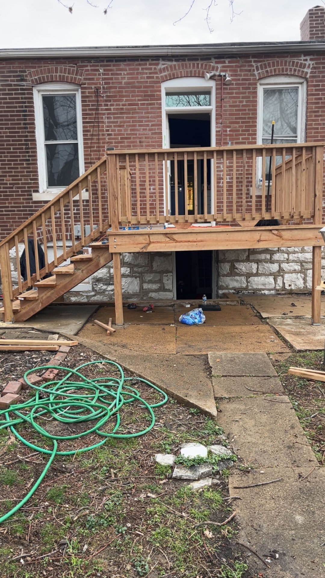 Long wood deck with railing and staircase in St. Louis County